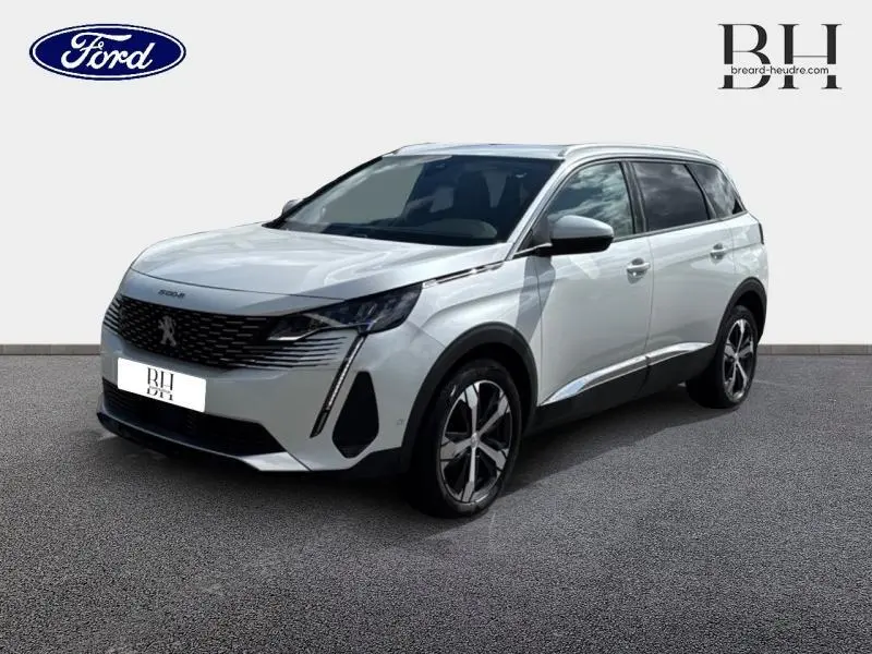 Peugeot 5008 blanc nacré vue 3/4 avant droit avec calandre noire et jantes alliage distinctives.