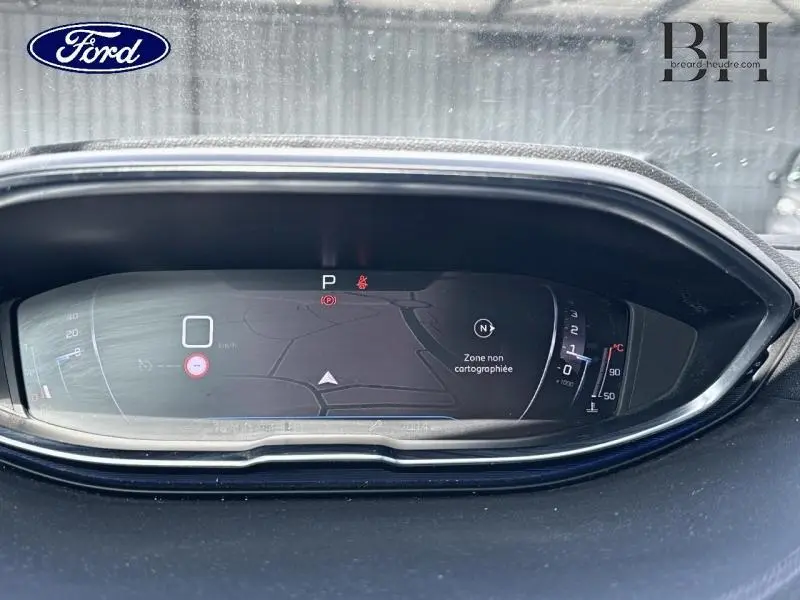 Affichage numérique du tableau de bord d'une Peugeot 5008 blanc nacré, vue frontale centrée sur l'écran de navigation.