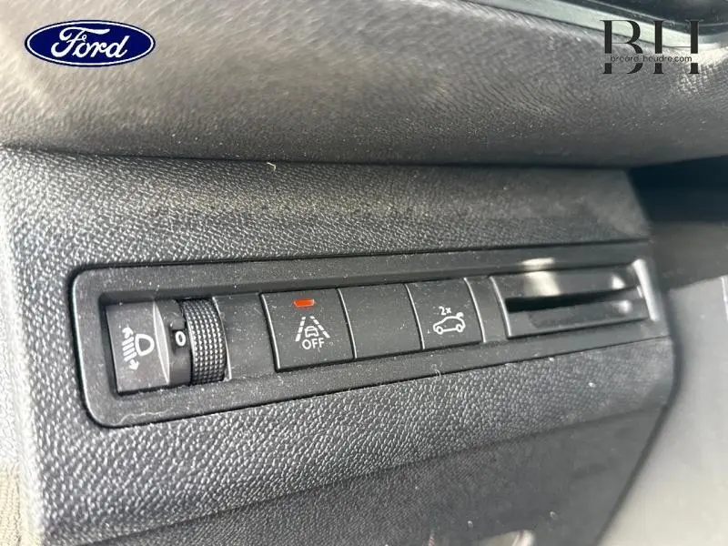 Détail des commandes intérieures noires avec réglage des phares et activation du hayon motorisé sur une Ford.