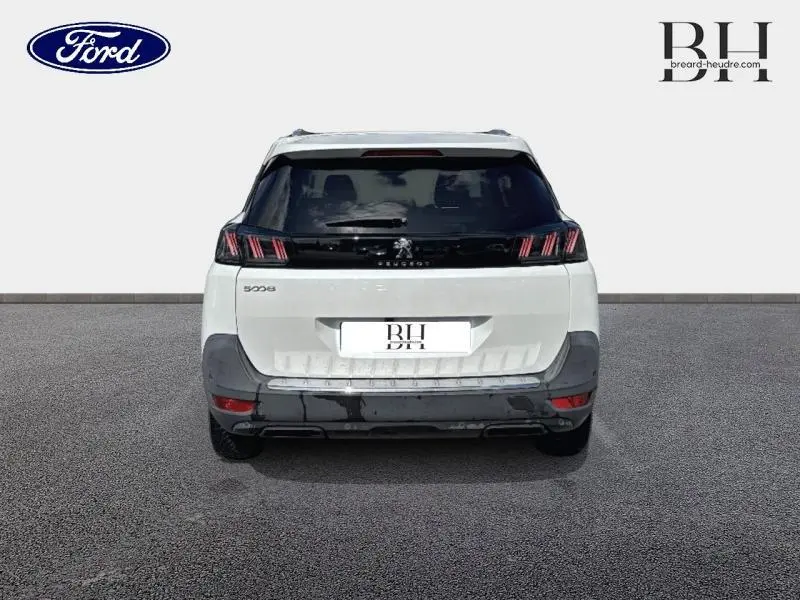 Vue arrière d'un Peugeot 5008 blanc nacré avec feux arrière LED et hayon motorisé mains libres.