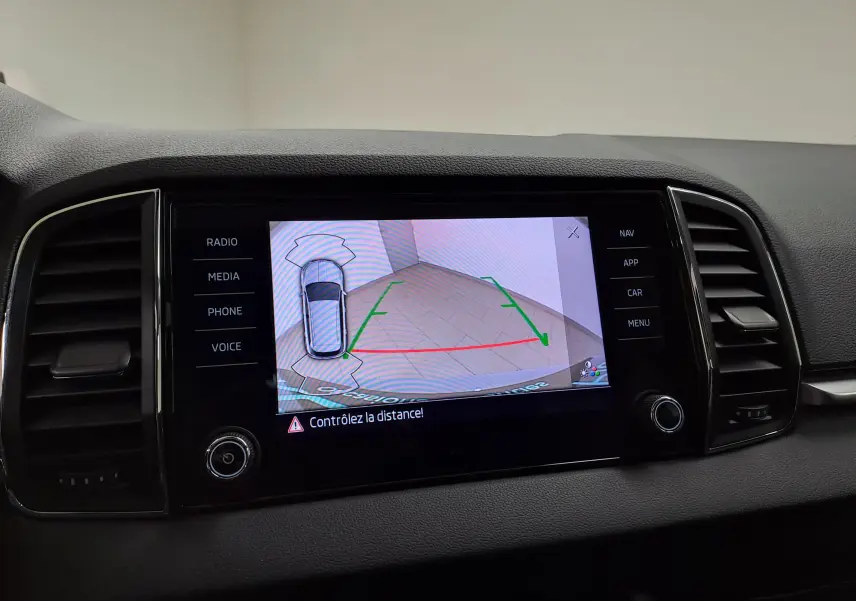 Écran central du Skoda Karoq 2023 affichant la caméra de recul avec guidage et alertes de distance.