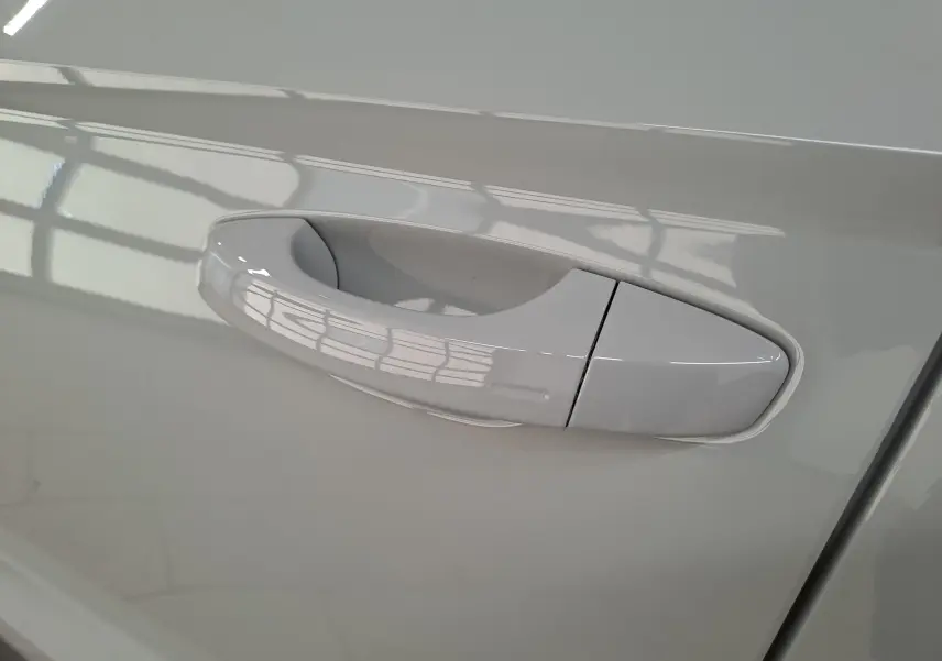 Poignée de porte côté droit du Skoda Karoq gris perle 2023, finition lisse et intégrée à la carrosserie.