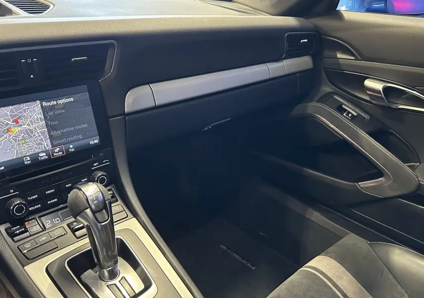 Vue intérieure côté passager de la Porsche 911 GT3 2018, mettant en valeur la console centrale et les finitions noires élégantes.