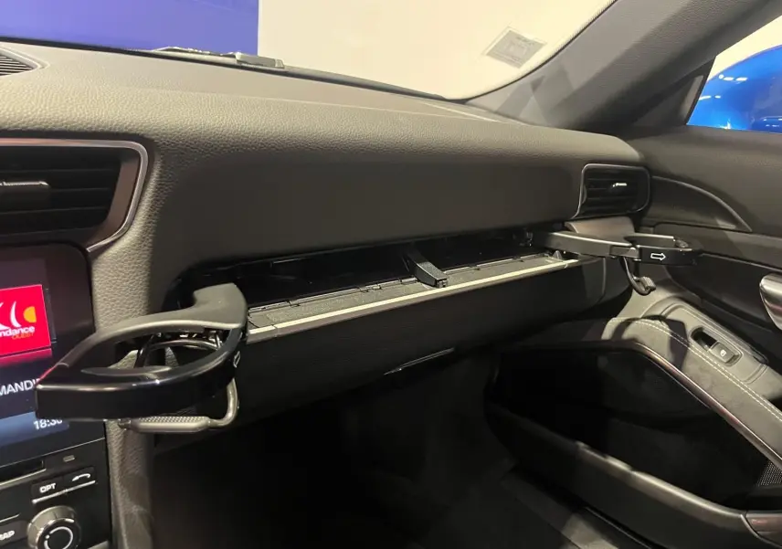 Vue intérieure du tableau de bord côté passager de la Porsche 911 GT3 avec porte-gobelets déployés et finition noire.