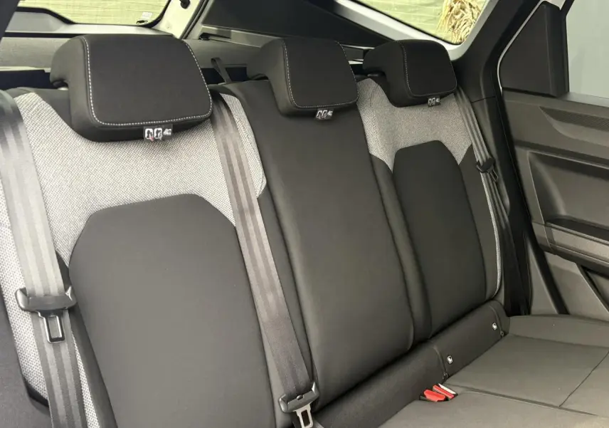 Vue intérieure des sièges arrière en tissu noir et gris du Dacia Bigster 2025, avec appuie-têtes et ceintures visibles.