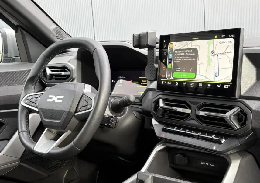 Vue rapprochée de l'intérieur du Dacia Bigster 2025, montrant le volant multifonction et l'écran tactile de navigation.