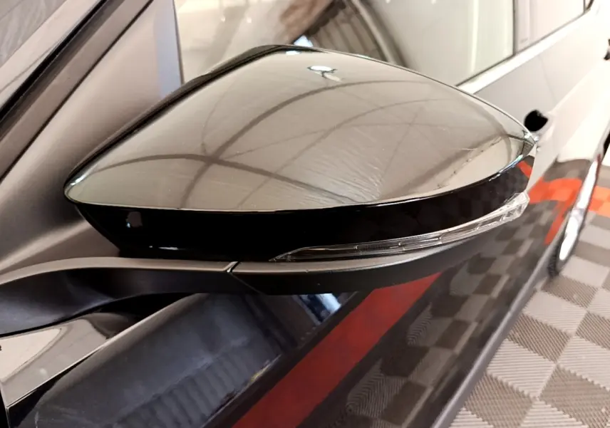 Gros plan sur le rétroviseur droit noir brillant du Volkswagen T-Cross 1.0 TSI 110ch DSG Carat 2022.