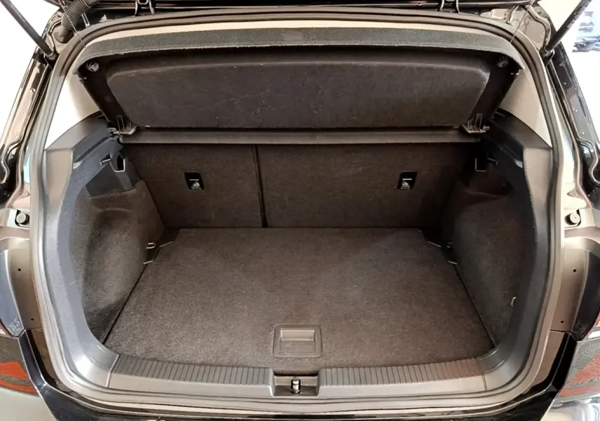 Coffre ouvert vue arrière d’un Volkswagen T-Cross noir, espace de rangement propre et spacieux sans chargement.