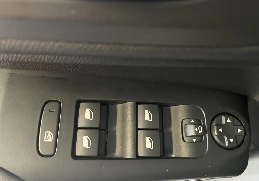 Gros plan sur les commandes électriques des vitres et rétroviseurs côté conducteur d'un Citroën C5 Aircross gris platinium 2025.