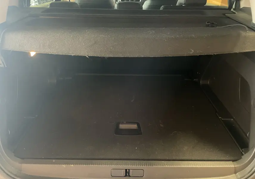 Coffre ouvert vu de l'arrière du Citroën C5 Aircross gris platinium, montrant l'espace de chargement vide avec cache-bagages.