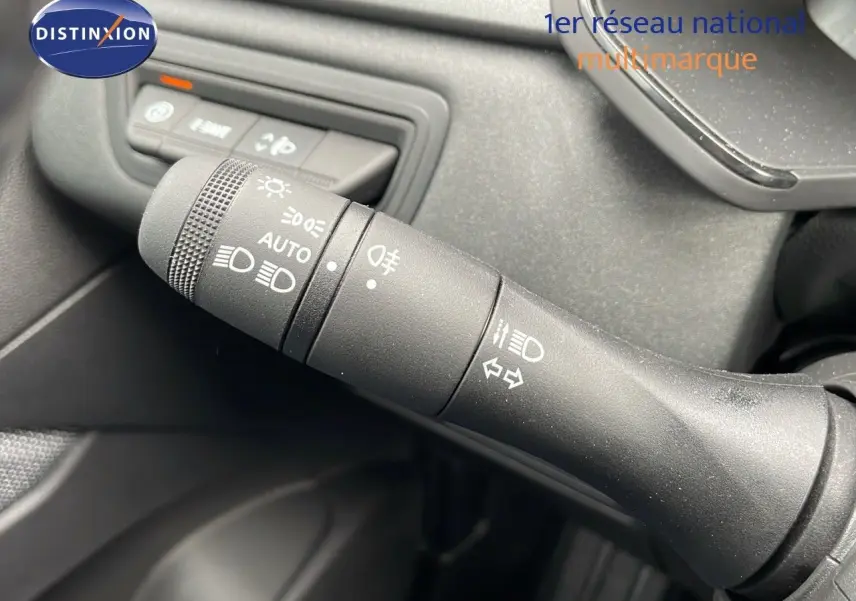 Gros plan sur la commande des feux et clignotants du Renault Captur gris rafale, intérieur noir.