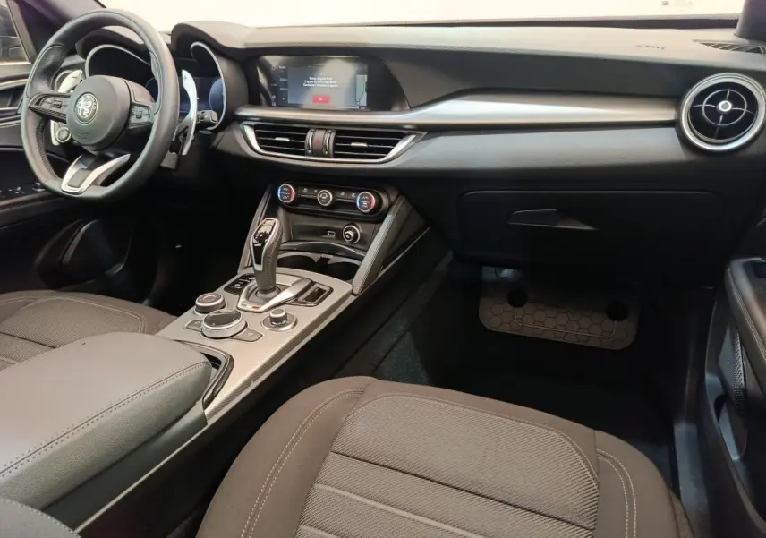 Intérieur de l'Alfa Romeo Stelvio 2.2 TD Sprint 2024, vue côté passager, tableau de bord et console centrale noirs.