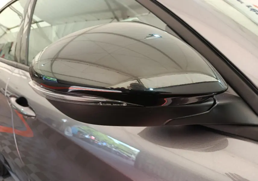 Rétroviseur côté droit gris foncé de l'Alfa Romeo Stelvio 2024 avec clignotant intégré, vue rapprochée.