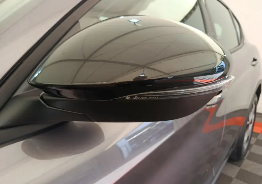Rétroviseur côté droit noir brillant sur Alfa Romeo Stelvio gris foncé, vue rapprochée du côté avant.