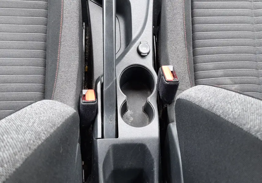 Vue plongeante sur la console centrale noire du Peugeot 2008 2020, avec frein à main manuel et sièges tissu gris.