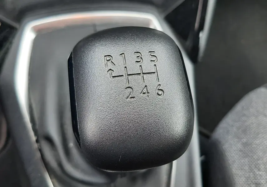 Gros plan sur le levier de vitesses manuel noir du Peugeot 2008 gris Artense, montrant les six rapports et la marche arrière.