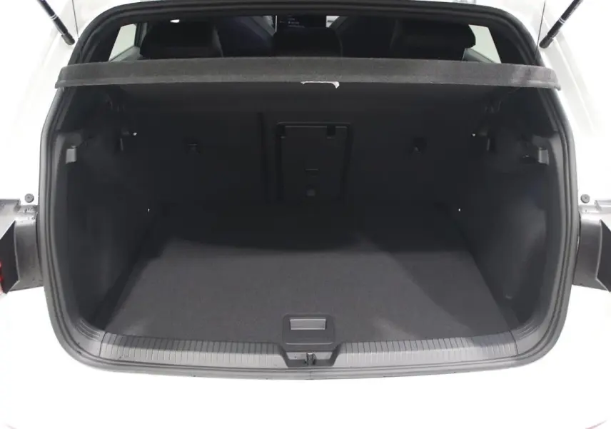 Coffre ouvert vu de l'arrière d'une Volkswagen Golf blanche 2025 avec intérieur noir et hayon relevé.