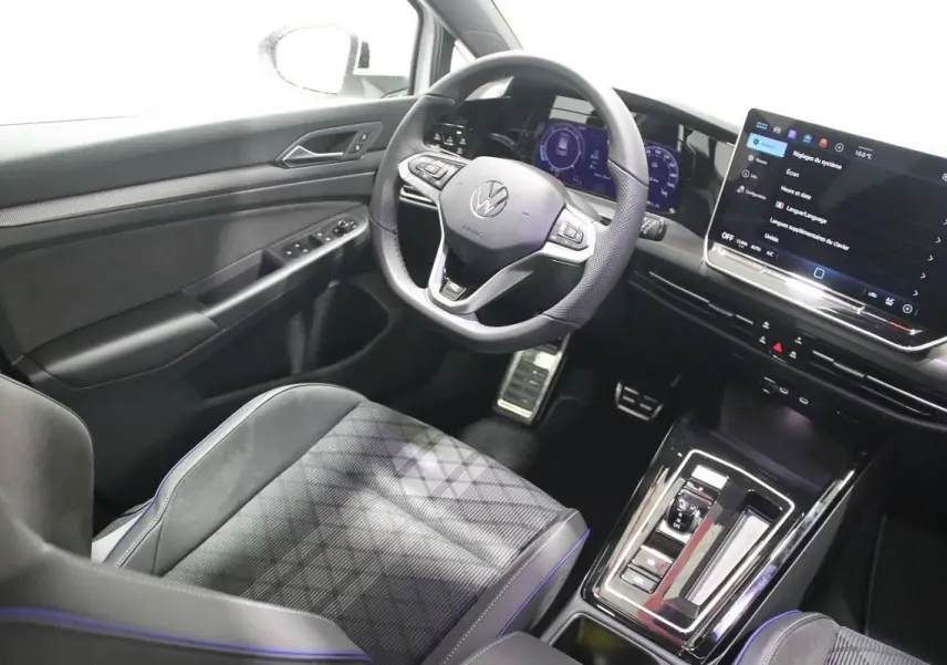 Vue intérieure côté conducteur de la Volkswagen Golf 2.0 TDI 150 DSG R-Line avec volant cuir et écran tactile central.