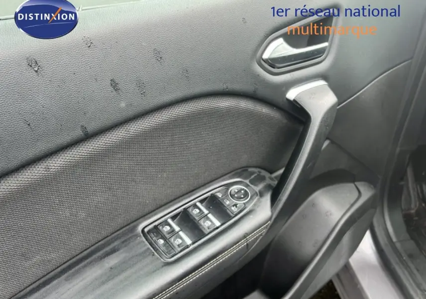 Détail de la porte avant gauche du Renault Symbioz gris cassiopée métal, avec commandes électriques des vitres et poignée intérieure.