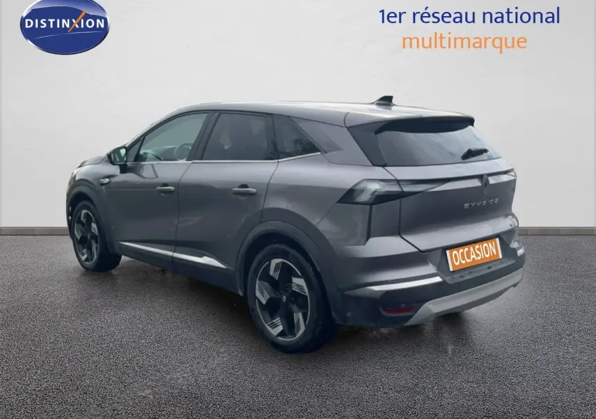 Vue 3/4 arrière droite d’un Renault Symbioz gris cassiopée métallisé avec jantes modernes et feux arrière LED.