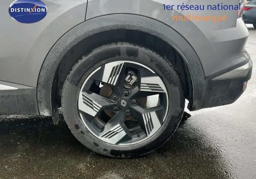 Gros plan sur la roue arrière droite du Renault Symbioz gris Cassiopée métal avec jante stylisée bicolore.