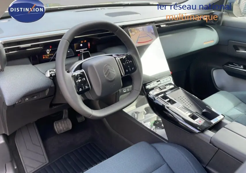 Vue intérieure côté conducteur du Citroën C5 Aircross Hybrid 2026, avec tableau de bord moderne et sellerie tissu bleu.