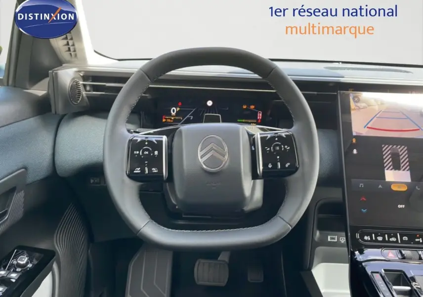Vue intérieure centrée sur le volant multifonction du Citroën C5 Aircross Hybrid 2026 avec écran tactile et caméra de recul.