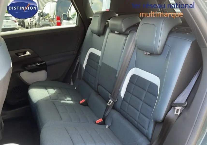 Vue intérieure des sièges arrière du Citroën C5 Aircross Hybrid 2026 avec sellerie tissu et cuir noir et détails gris.