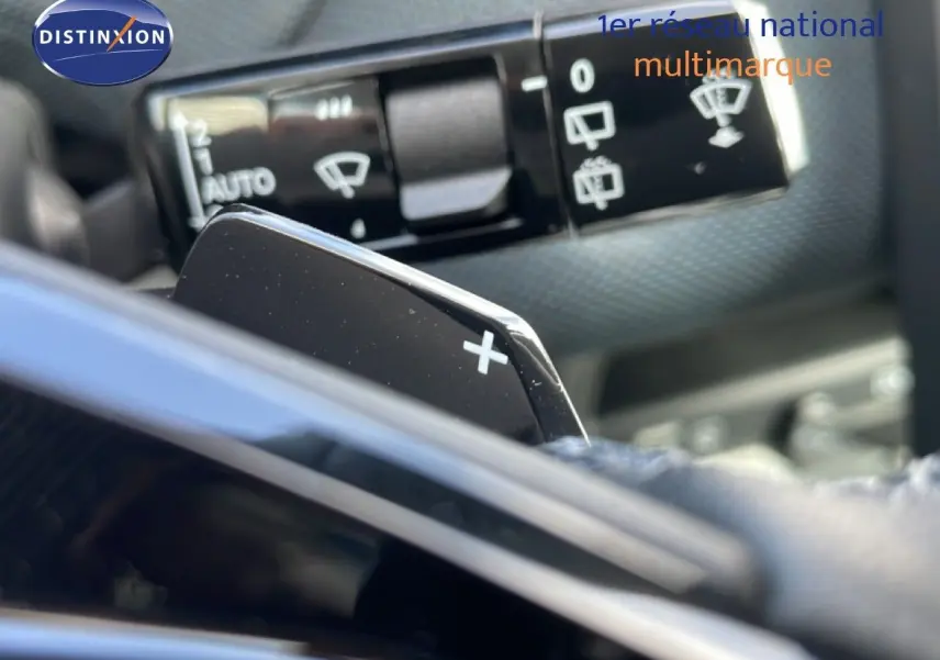 Gros plan sur la palette de changement de vitesse "+" côté droit du volant d'un Citroën C5 Aircross Hybrid vert Astoria.