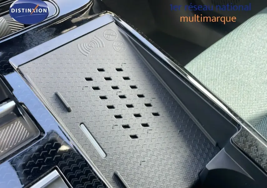Gros plan sur la console centrale du Citroën C5 Aircross Hybrid 2026, avec tapis de charge sans fil et siège tissu vert Astoria.