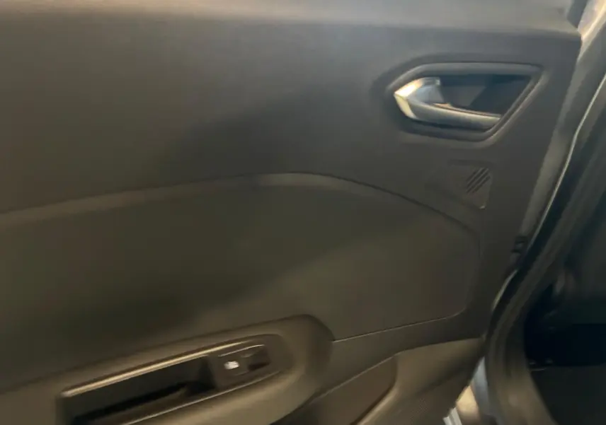 Vue intérieure côté gauche sur la porte arrière d'une Renault Clio gris schiste, avec poignée et commande de fenêtre.