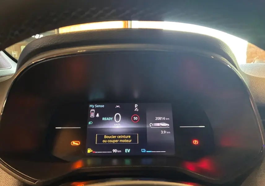Vue rapprochée du tableau de bord numérique de la Renault Clio gris schiste, affichant les alertes et informations de conduite.