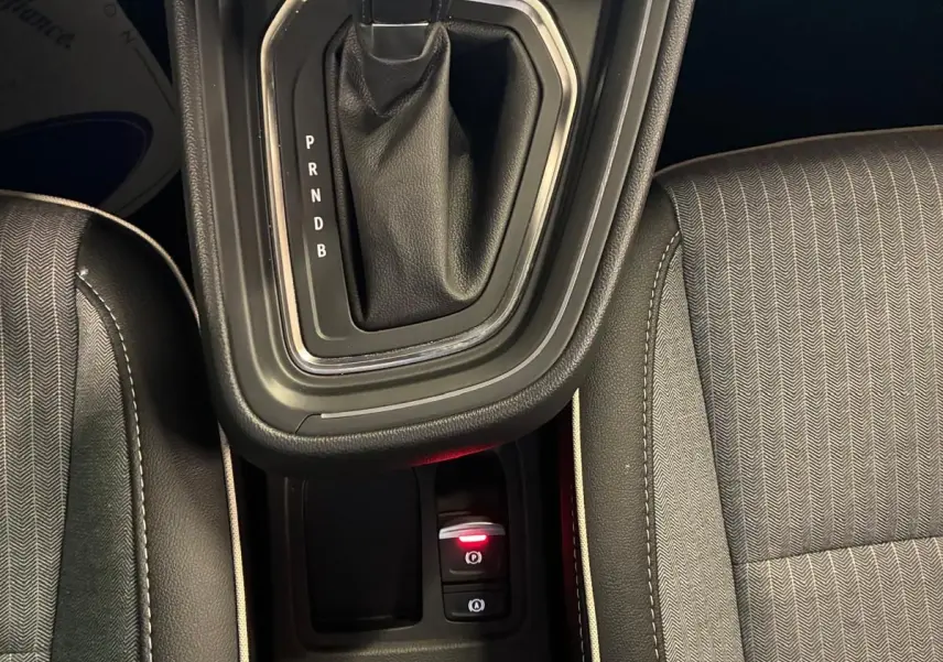 Vue plongeante sur la console centrale de la Renault Clio 2025, levier de vitesse automatique et siège tissu gris noir.