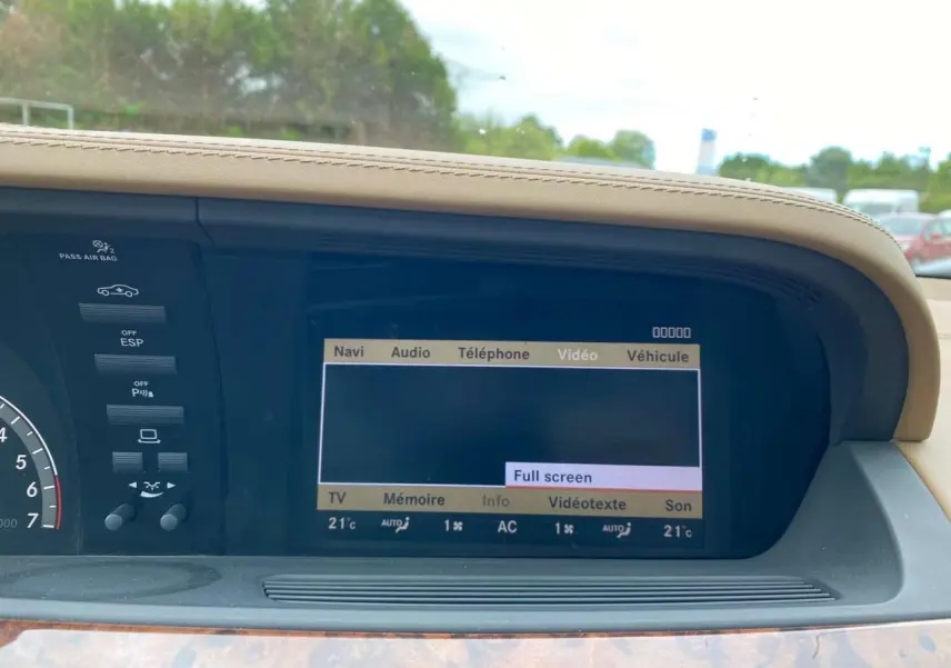 Écran central multimédia allumé dans l'habitacle beige d'une Mercedes Classe S 600 L noire, vue de face rapprochée.