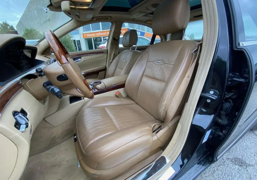 Intérieur de la Mercedes Classe S 600 L 2007, vue côté conducteur, sellerie cuir beige et bois Designo noir extérieur.