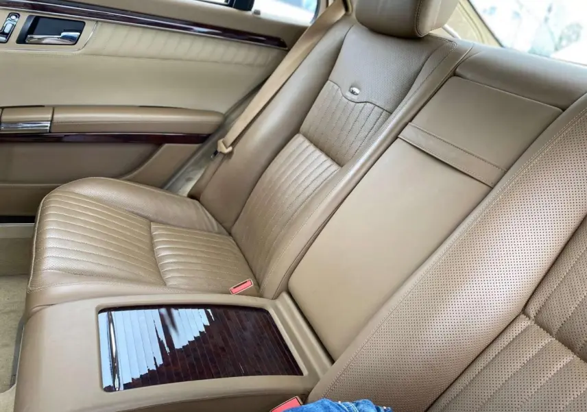 Vue rapprochée de la banquette arrière en cuir beige de la Mercedes Classe S 600 L avec inserts bois Designo.