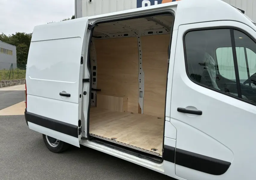 Opel Movano Fourgon blanc vu de côté droit avec porte coulissante ouverte montrant l'intérieur en bois clair.