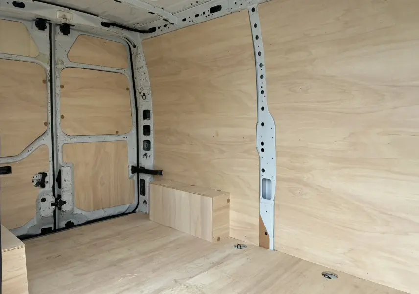 Intérieur du fourgon Opel Movano blanc 2017, vue latérale droite montrant l'aménagement en bois clair.