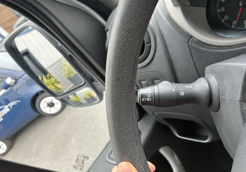 Vue intérieure rapprochée du volant noir et du commodo gauche de l'Opel Movano Fourgon blanc, avec rétroviseur extérieur visible.