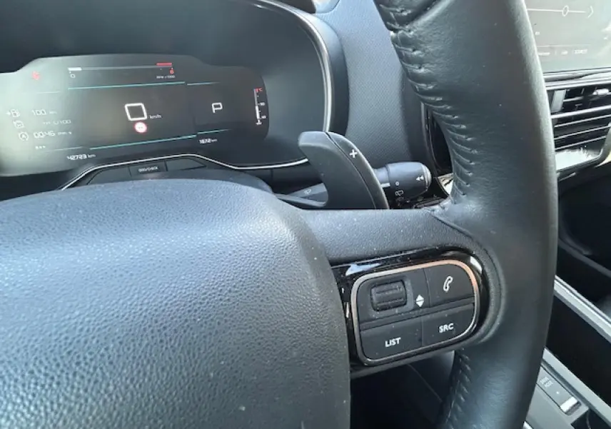 Gros plan sur le volant noir et le tableau de bord numérique du Citroën C5 Aircross 2022, version essence Gris Platinium.