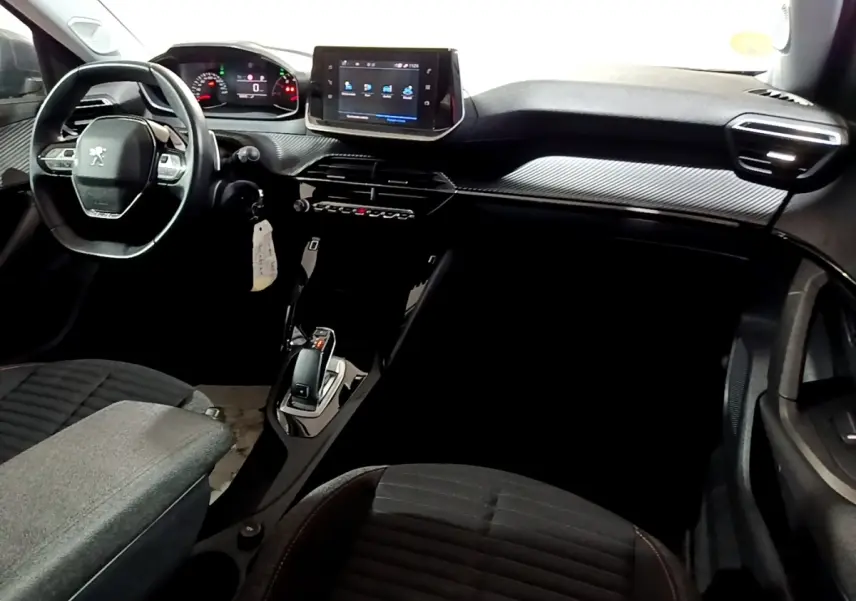 Vue intérieure côté conducteur du Peugeot 2008 gris clair, mettant en valeur le volant cuir multifonctions et l’écran tactile central.