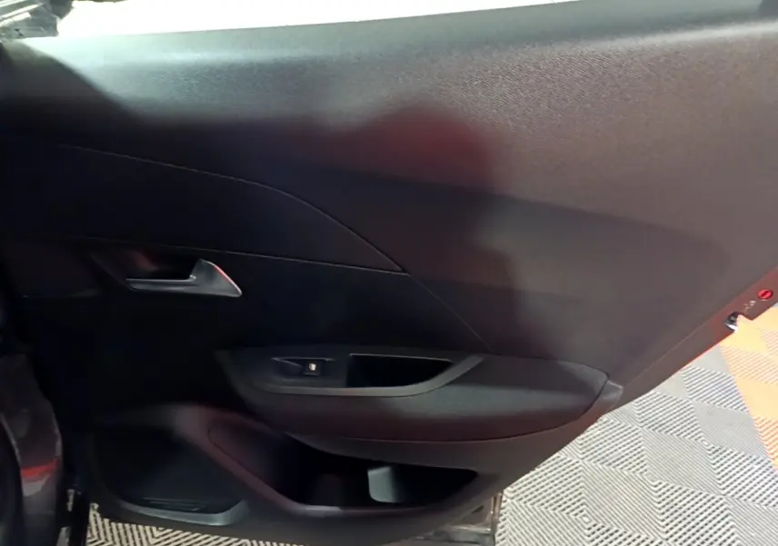 Vue intérieure du panneau de porte arrière gauche noir du Peugeot 2008 gris clair 2021.