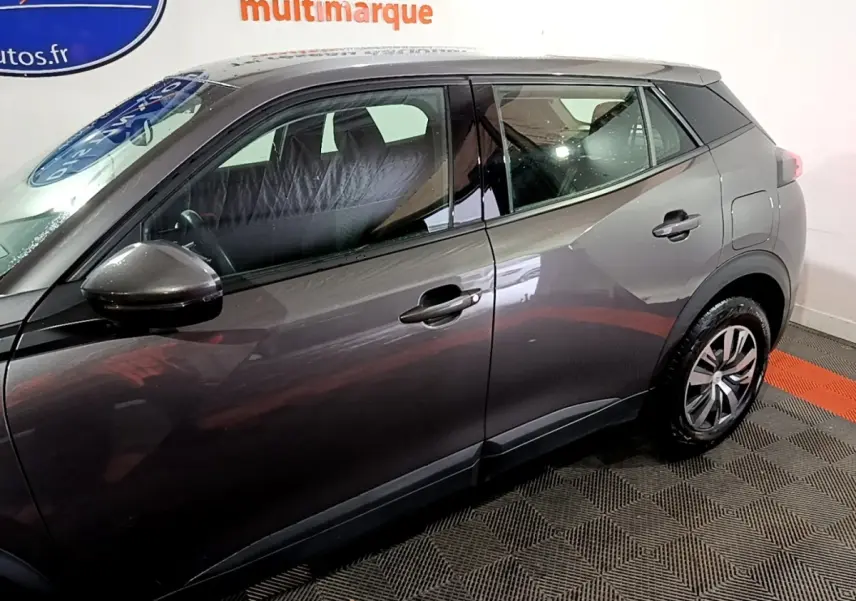 Profil côté gauche du Peugeot 2008 gris clair, mettant en valeur les lignes épurées et les jantes alliage.
