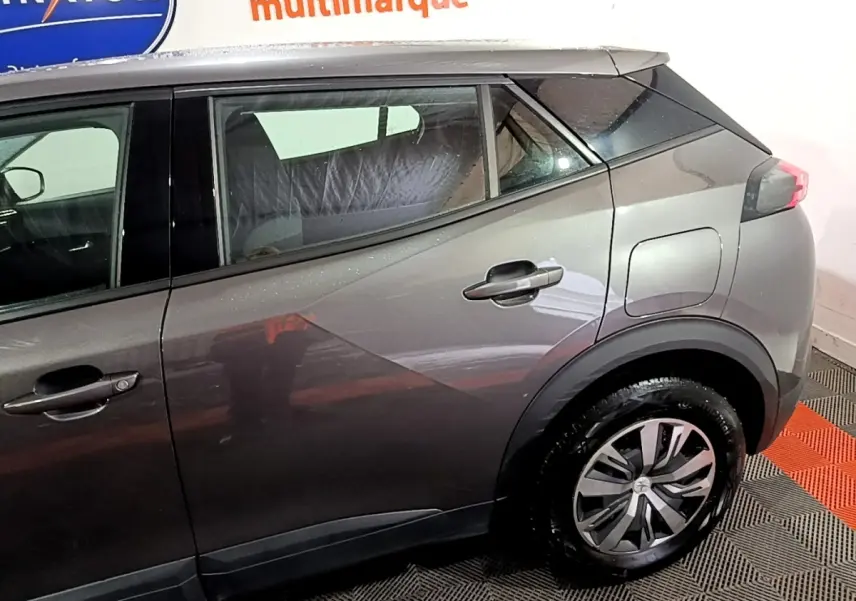 Vue latérale droite d’un Peugeot 2008 gris clair, mettant en valeur la ligne de caisse et les jantes modernes.