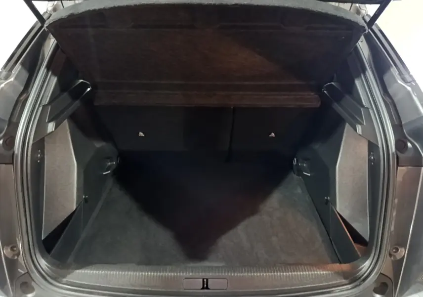 Coffre ouvert vu de l'arrière d'un Peugeot 2008 gris clair, montrant l'espace de chargement vide et la tablette cache-bagages.