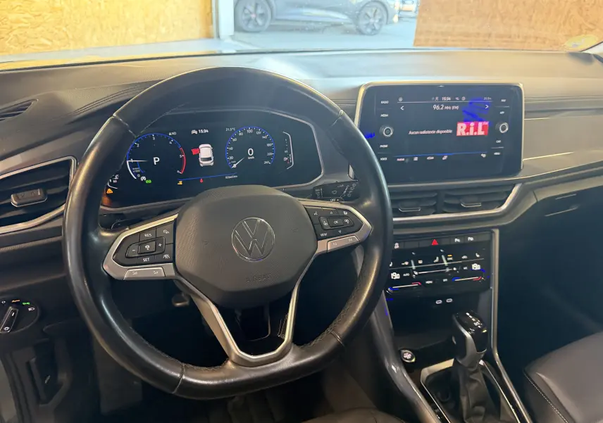 Vue intérieure centrée sur le volant et le tableau de bord numérique du Volkswagen T-Roc 2.0 TDI bleu de 2022.
