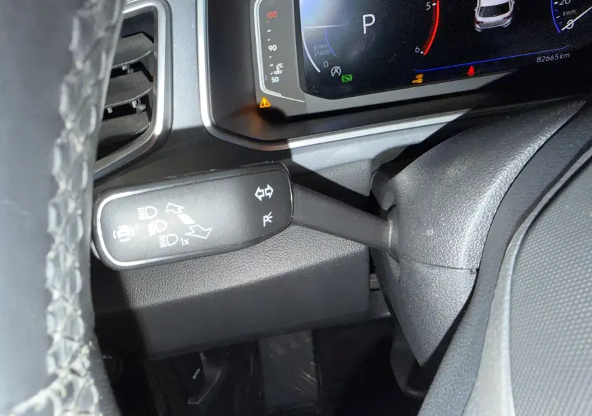 Gros plan sur le commodo gauche et le tableau de bord numérique du Volkswagen T-Roc 2.0 TDI bleu, intérieur noir.