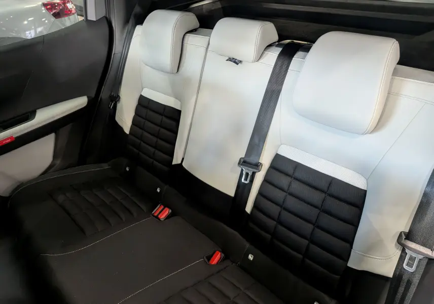 Vue intérieure arrière des sièges bicolores noir et blanc en cuir du Citroën C3 Aircross hybride 2026.