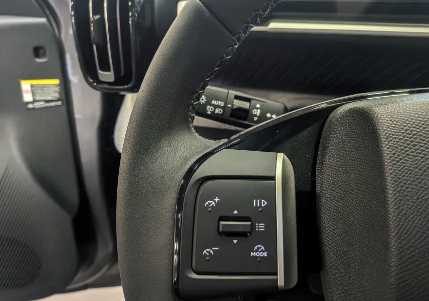 Gros plan sur le volant noir du Citroën C3 Aircross 2026 hybride, montrant les commandes de régulateur de vitesse à gauche.