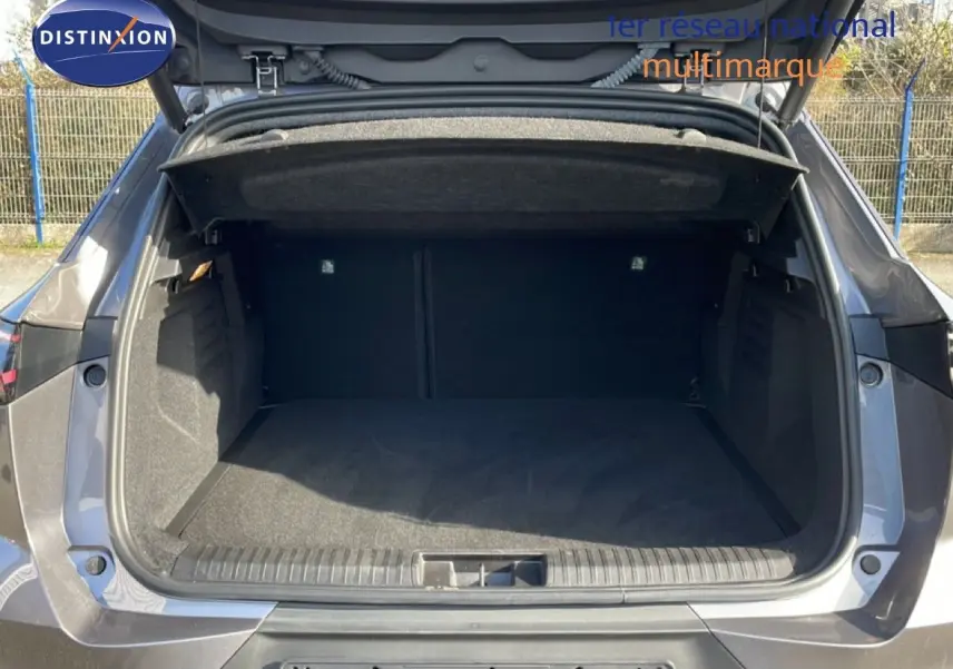 Coffre ouvert vu de l'arrière d'une Renault Symbioz gris cassiopée métal, montrant un espace de chargement vide et spacieux.